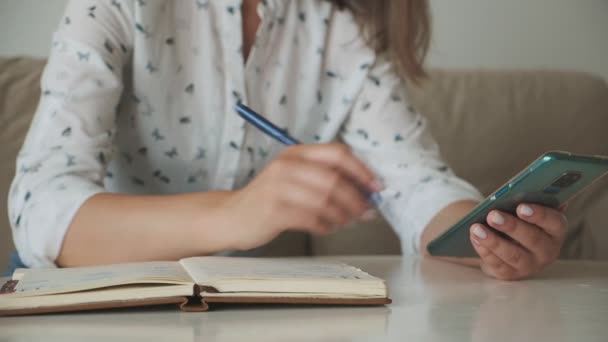 Vrouw Handen Met Behulp Van Mobiele Telefoon Schrijven Notebook — Stockvideo