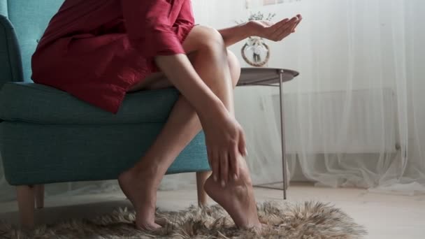 Vrouw Brengt Verzorging Crème Benen Maakt Voet Massage Handen Zittend — Stockvideo