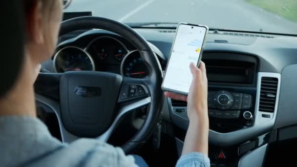 Araba kullanan kadın cep telefonundan mesaj gönderiyor, mesaj yazma ve sürme — Stok video