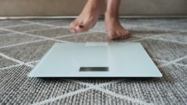 Terazide ağırlıklar, evde yerde duran kadın bacakları.