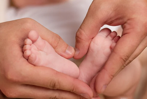 Bebé pies en manos masculinas — Foto de Stock