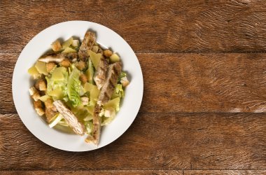 Sezar salatası kruton ve ahşap masa üzerinde ızgara tavuk