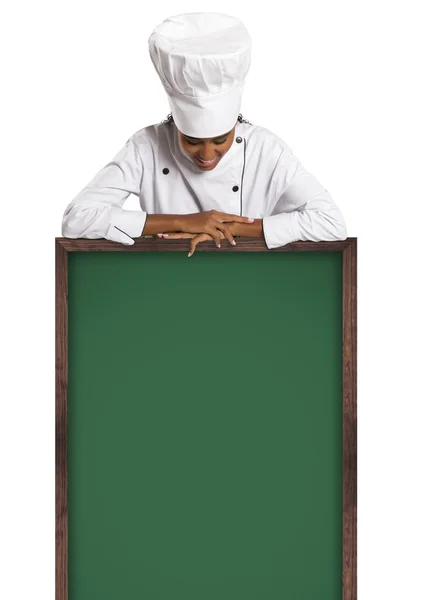 Chef. Woman cook showing empty menu chalkboard with copy space. — Stock Photo, Image