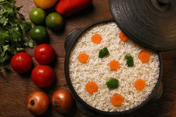 Smakelijk gezond rijst met groentjes in witte plaat op een hout — Stockfoto