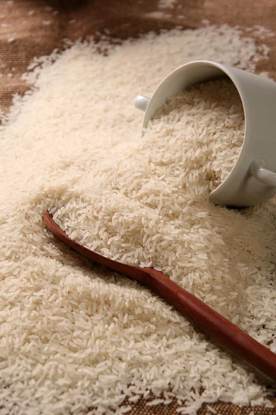 Witte lange ongekookte rijst op houten lepel — Stockfoto