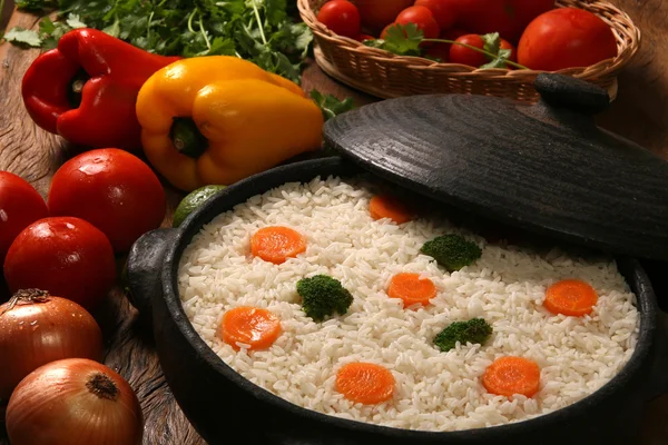 Riz sain appétissant avec des légumes dans une assiette blanche sur un bois — Photo