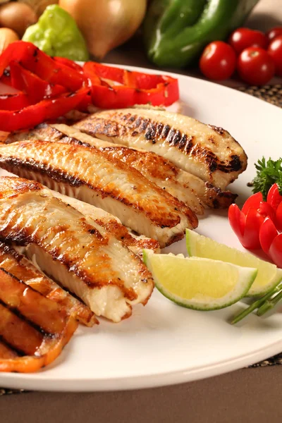 Pescado a la parrilla con verduras en el plato . — Foto de Stock