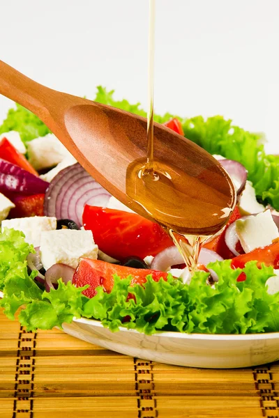 Primer plano de cuchara con aceite de oliva vertido y ensalada vegetal —  Fotos de Stock
