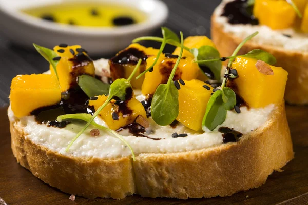 Bruschetta doğranmış mango, tere, fesleğen ve keçi peynirli f