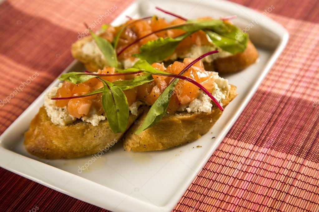 Bruschetta with chopped mango, cress and goat cheese on fresh ba Stock  Photo by ©Paulovilela 118818128