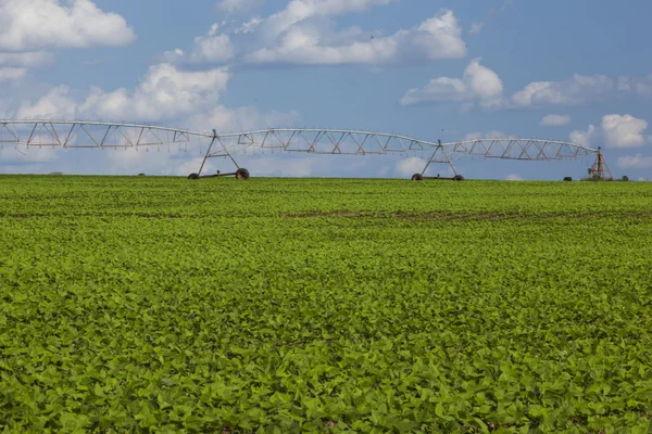 Industrial irrigation equipment on farm field under a blue sky i