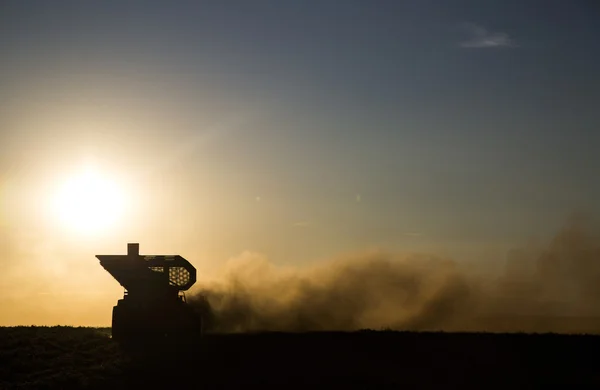Máquina rural que trabalha no campo agrícola ao pôr do sol . — Fotografia de Stock
