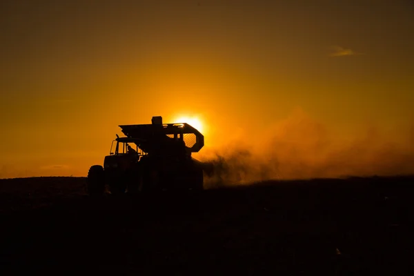 Macchine rurali che lavorano nel campo agricolo al tramonto . — Foto Stock