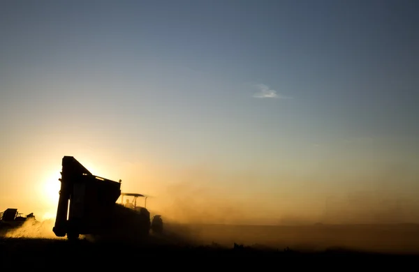 Máquina rural que trabalha no campo agrícola ao pôr do sol . — Fotografia de Stock