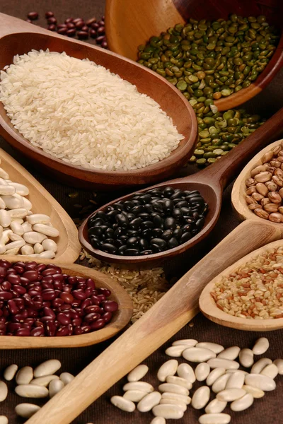 Ensembles de grains pelés, riz et haricots dans une cuillère en bois — Photo