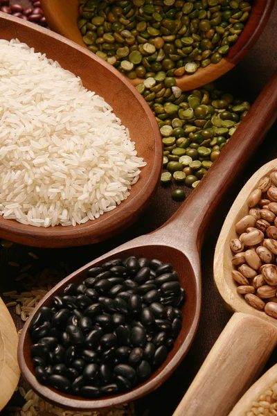 Ensembles de grains pelés, riz et haricots dans une cuillère en bois — Photo
