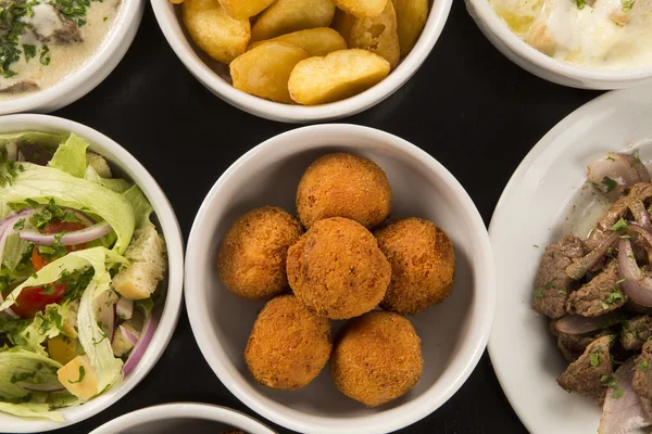 Mixed brazilian snacks, including pastries, fried chicken, salad — Stock Photo, Image