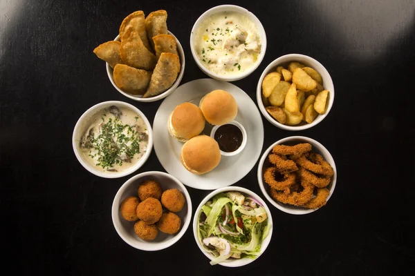 Petiscos brasileiros mistos, incluindo bolos, frango frito, salada — Fotografia de Stock