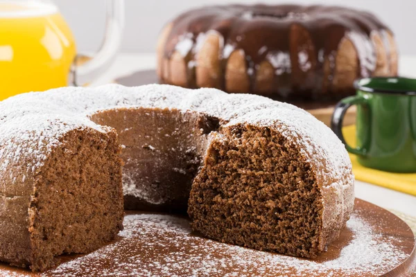 Bolo de chocolate na mesa com bolo de cenoura no fundo . — Fotografia de Stock