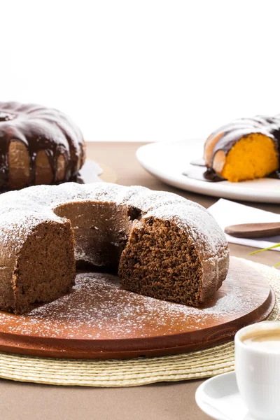 Schokoladenkuchen auf dem Tisch mit Karottenkuchen im Hintergrund. — Stockfoto