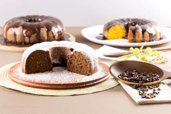 Bolo de chocolate na mesa com bolo de cenoura no fundo . — Fotografia de Stock