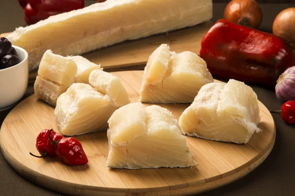 Bacalhau salgado na mesa de madeira com ingredientes — Fotografia de Stock