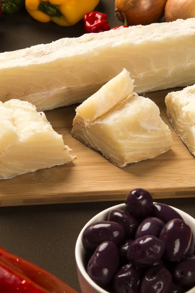 Salted codfish on the wooden table with ingredients — Stock Photo, Image