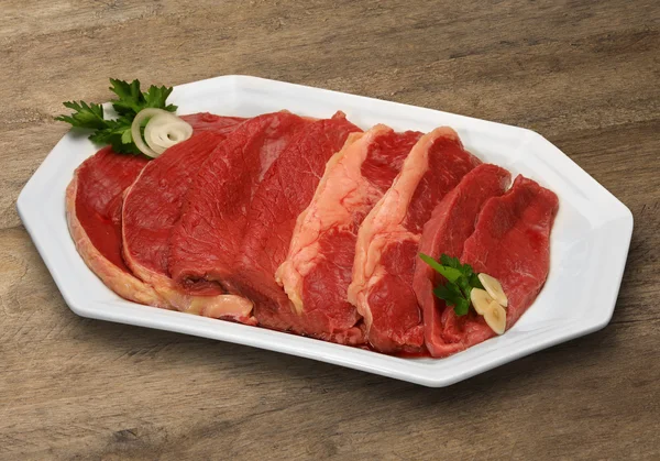 Selezione di carne cruda su tagliere in legno . — Foto Stock