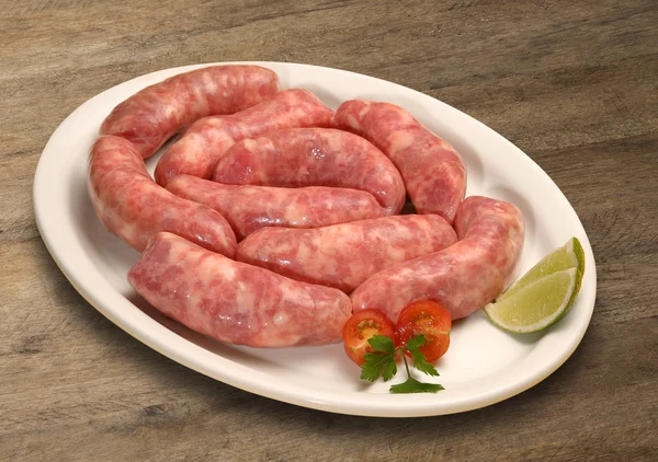 Fresh raw sausage on the old wooden background — Stock Photo, Image