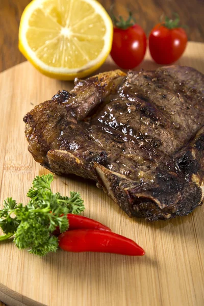 Mięso z grilla żeberka na białe płytki z pomidorów szczypiorek i ciemne h — Zdjęcie stockowe