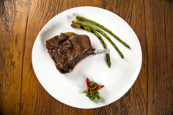 Grillat kött revben på vit platta med tomater gräslök och mörka h — Stockfoto
