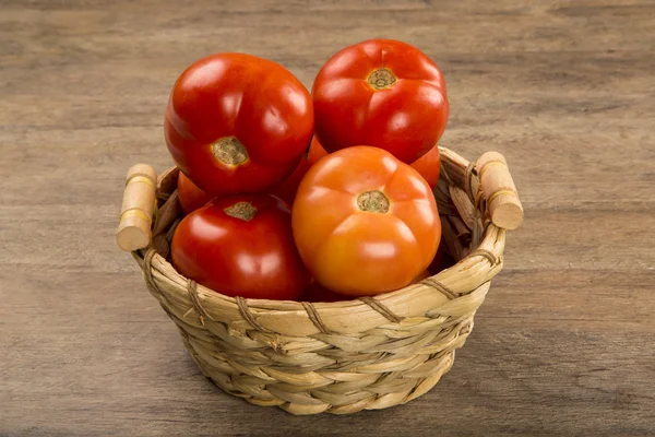 Alguns tomates sobre um fundo de madeira. Produtos hortícolas frescos . — Fotografia de Stock
