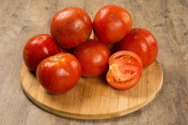 Alcuni pomodori su uno sfondo di legno. Ortaggi freschi . — Foto Stock