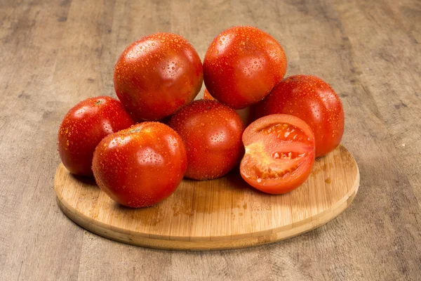 Alcuni pomodori su uno sfondo di legno. Ortaggi freschi . — Foto Stock