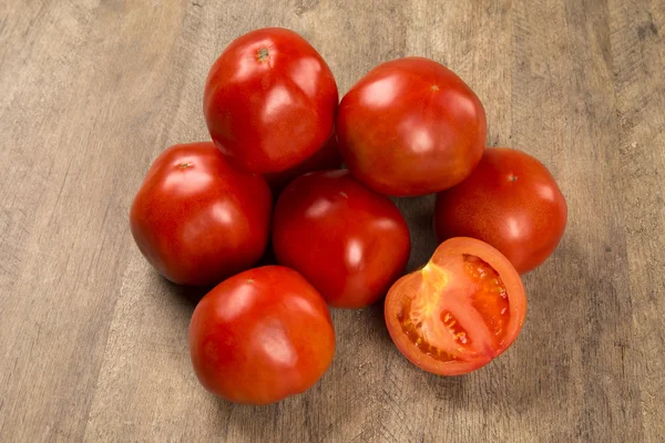 Sommige tomaten op een houten achtergrond. Vers fruit. — Stockfoto