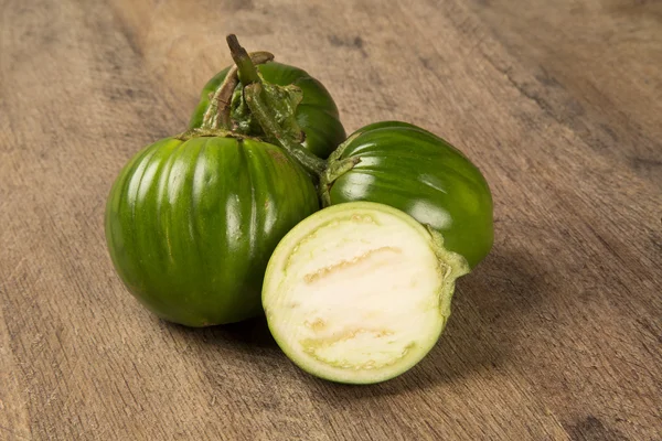 Sommige groene Afrikaanse aubergines over een houten oppervlak — Stockfoto