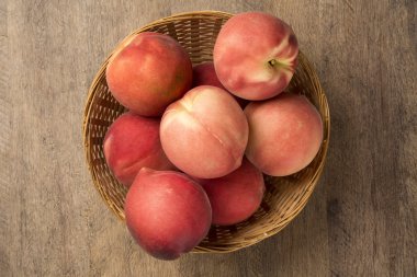 Biraz şeftali bir ahşap yüzey üzerinde bir sepet içinde