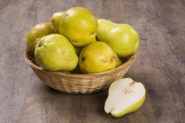 Ahşap bir yüzey üzerinde bir sepet içinde bazı armut