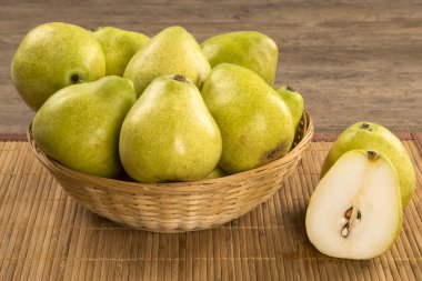 Ahşap bir yüzey üzerinde bir sepet içinde bazı armut