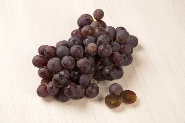 Unas uvas rojas sobre un fondo blanco — Foto de Stock