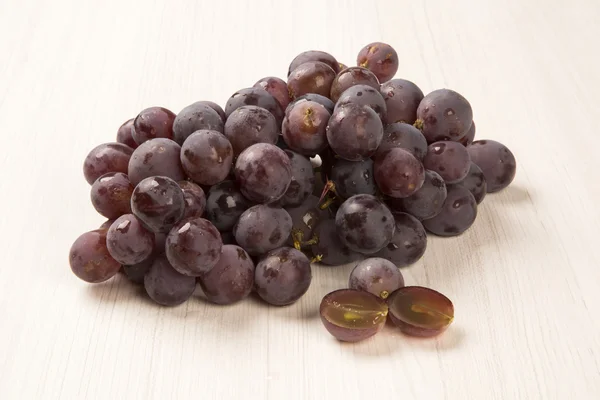 Unas uvas rojas sobre un fondo blanco — Foto de Stock