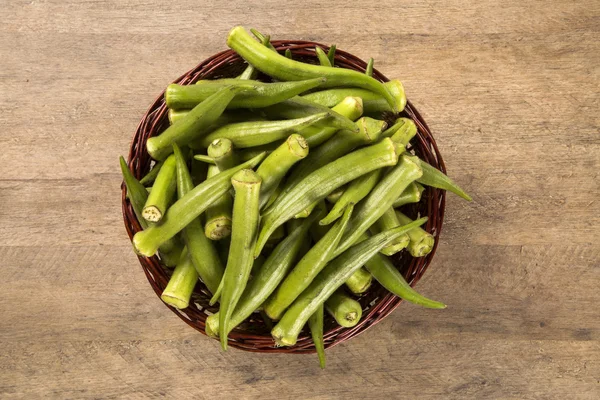 Okra op houten achtergrond — Stockfoto