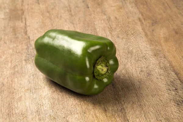 Some green peppers over a wooden surface. — Stock Photo, Image