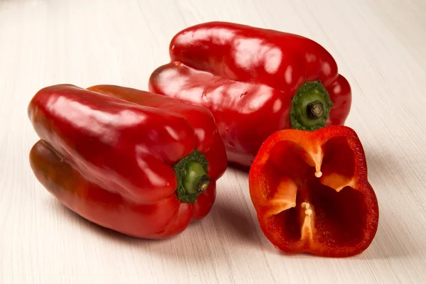 Algunos pimientos rojos sobre una superficie de madera — Foto de Stock