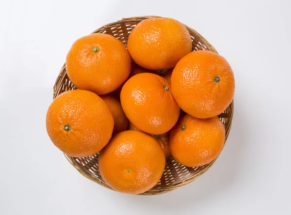 Algumas tangerinas em uma cesta sobre um fundo branco . — Fotografia de Stock