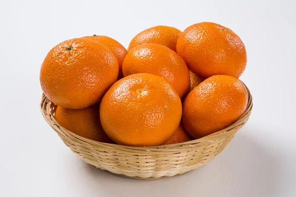 Některé mandarinky v košíku na bílém pozadí. — Stock fotografie