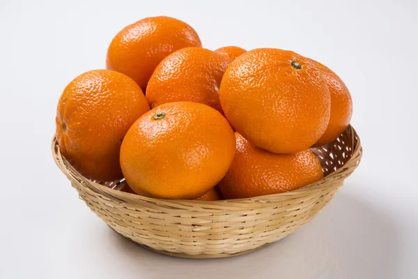Mandarinen in einem Korb vor weißem Hintergrund. — Stockfoto