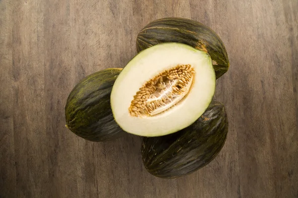 Algunos melones sobre una superficie de madera — Foto de Stock