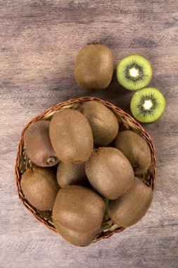 Ahşap bir yüzey üzerinde bir sepet içinde biraz kivi