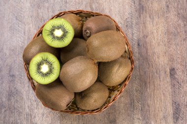 Ahşap bir yüzey üzerinde bir sepet içinde biraz kivi